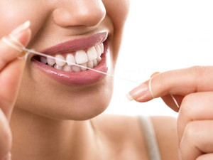 Young Woman Using a Dental Floss