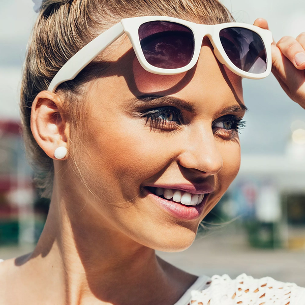 Portrait Of Beautiful Blonde Young Woman In Sunglasses On Blue Sky Background
